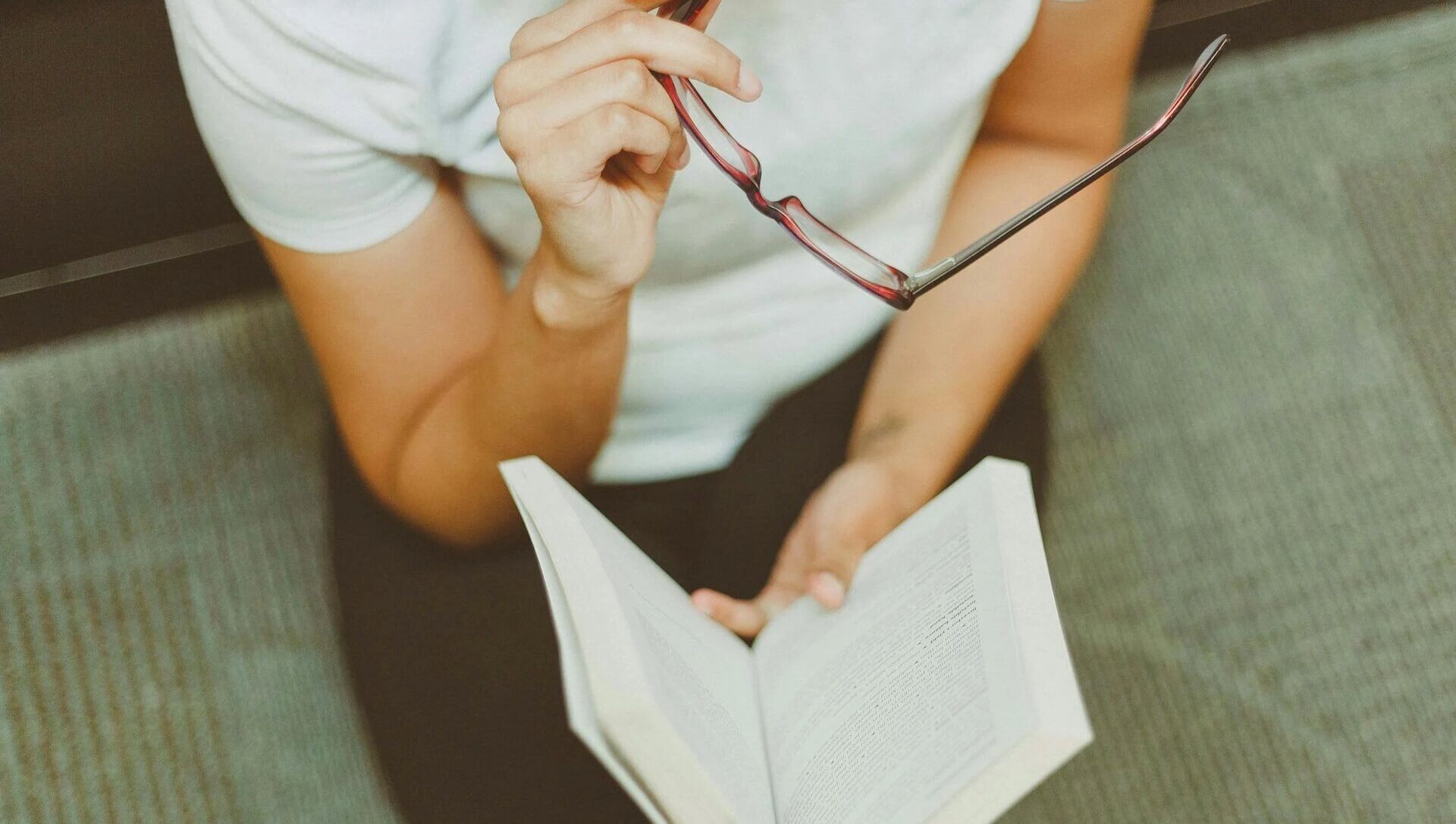 A Woman Holding Book and a Pair of Glasses; Why Feedback Is Vital for Every Screenwriter
