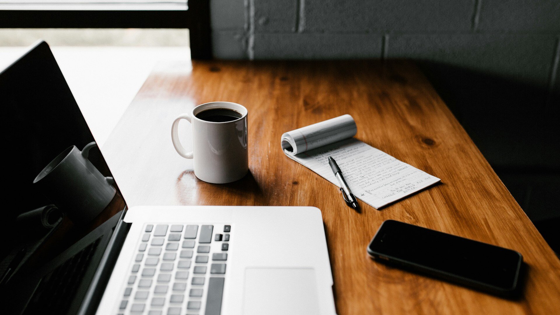 A laptop, notepad, and coffee on a wooden table, This Is What Managers Look for in a Script