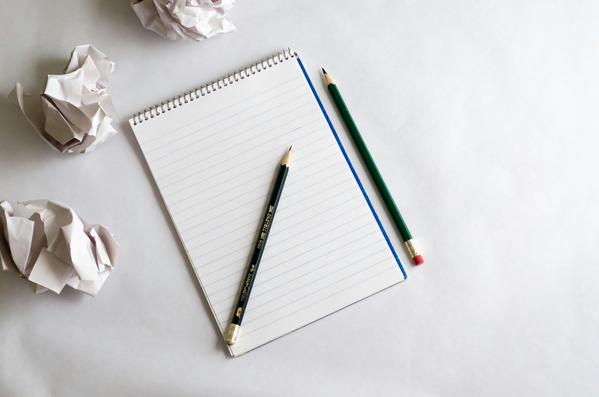 A pencil and notepad on a white table